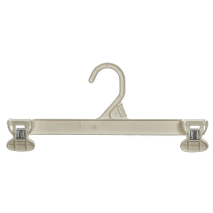 Beige plastic clothes hanger with adjustable pant clips, isolated on white background